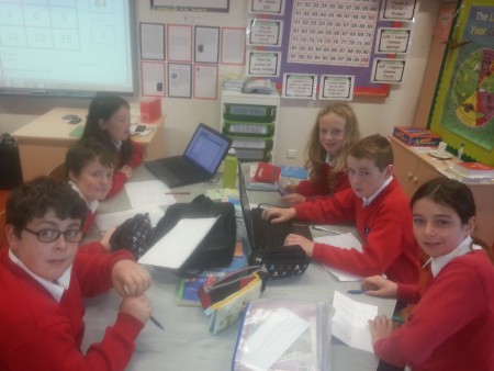 Evan, Dean, Caoimhe, Ryan and Ciara using the computers to solve maths problems.